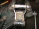 1995 Ford C-350 (Centurion Conversions) - A close-up view of a vehicle suspension component secured in a metal vise, ready for work.