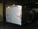1995 Ford C-350 (Centurion Conversions) - Rear view of a silver enclosed trailer with dual axles and red taillights.