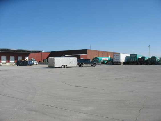 Dark SUV towing a silver trailer in a parking lot with a building in the background