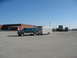 1995 Ford C-350 (Centurion Conversions) - 1995 Ford C-350 (Centurion Conversions) with a trailer in a parking lot. Other commercial trucks are visible in the distance.