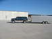 1995 Ford C-350 (Centurion Conversions) - A Ford SUV tows a large silver trailer on a clear day.