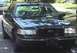 1998 Ford Crown Victoria - A black 1998 Ford Crown Victoria is parked on a street, seen from the front.