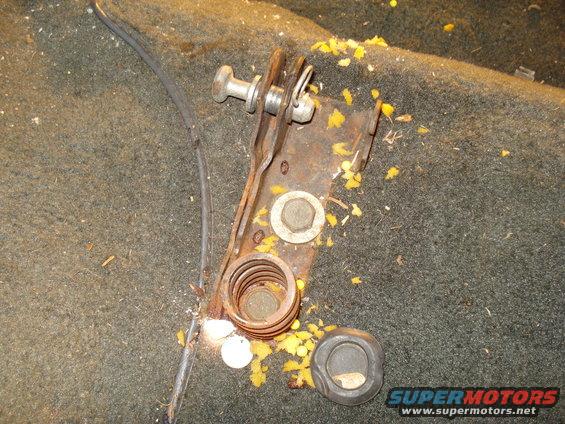 Rusty brake lever assembly with spring and cable on carpet