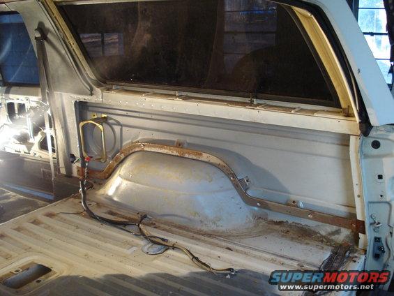 Interior of a 1991 Ford Bronco cargo area, showing the bed and rear window frame.