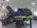 1990 Ford Bronco - 1990 Ford Bronco undergoing service on a hydraulic lift in a garage.