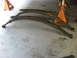1991 Ford Bronco - Leaf springs are shown resting on a concrete floor, with orange jack stands visible in the background.