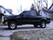 2005 Ford F-250 - Side view of a black 2005 Ford F-250 crew cab pickup truck.