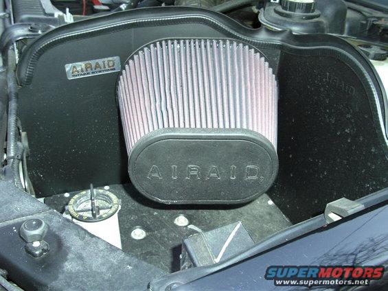Black AIRAID engine air intake system with a pinkish filter