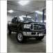 2005 Ford F-250 - This black 2005 Ford F-250 pickup truck is shown from a three-quarter front view in a garage.