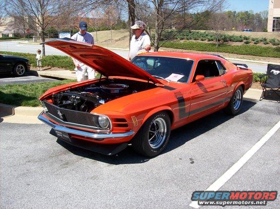 Orange 1970 Ford Mustang Boss 302 with hood open, showing engine