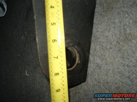 Measuring tape against a dark interior part with a circular opening