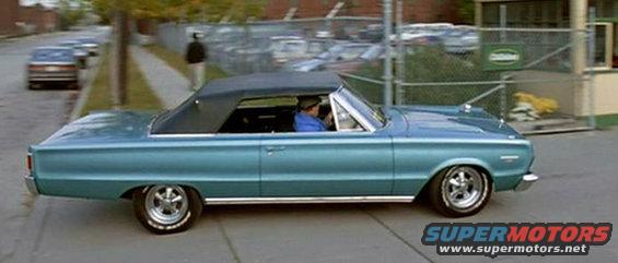 Blue 1967 convertible driving down street