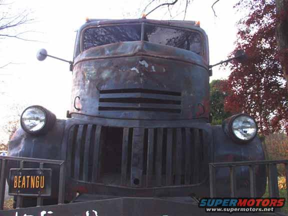 Front view of a rusty, old truck with a license plate that says BEATNGU