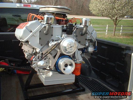 Engine with chrome accents and orange spark plug wires in a truck bed