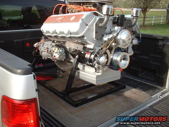 Ford V8 engine with "Ford" and "GT 351" visible, mounted on a stand in a truck bed