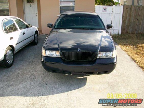 Front view of a dark 1998 Mercury Grand Marquis parked next to a white sedan