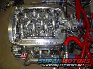 Shiny custom intake manifold with '24 VALVE DOHC' text, part of an engine build