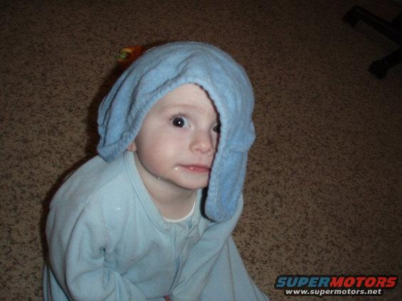 Kid with a blue towel on head, wearing blue pajamas