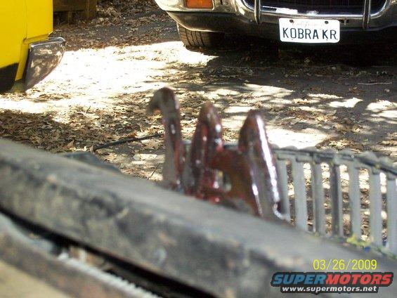 Hood latch mechanism with a license plate reading KOBRA KR visible behind it