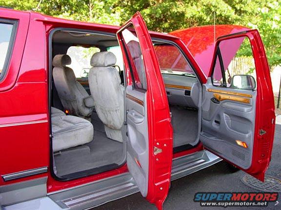 Red van interior with open doors showing front and rear seats