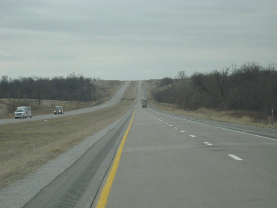 Highway stretching into the distance with trucks and vans on it