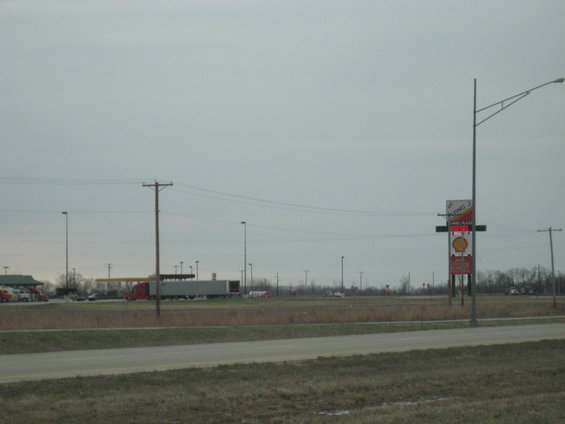Truck stop with a Shell sign and a long semi-trailer truck