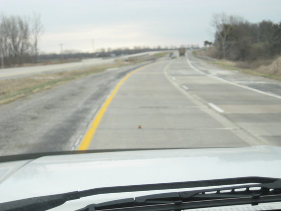 Interior view of a car on a highway with a truck in the distance