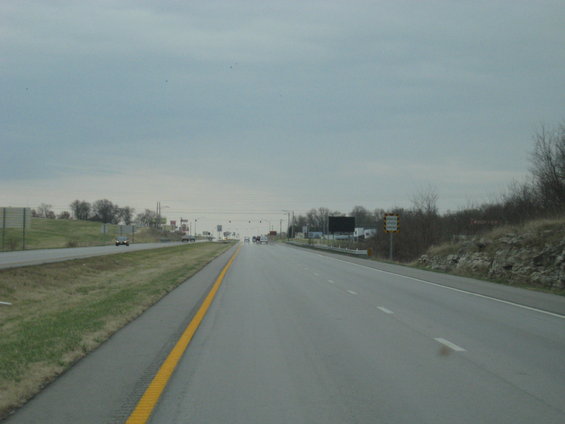 Highway scene with cars under a cloudy sky