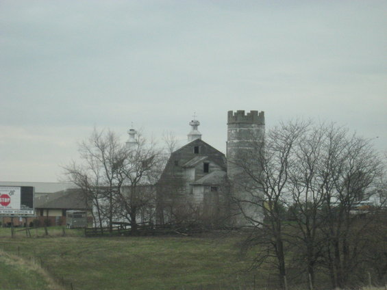 Barn and silo with a billboard in the distance