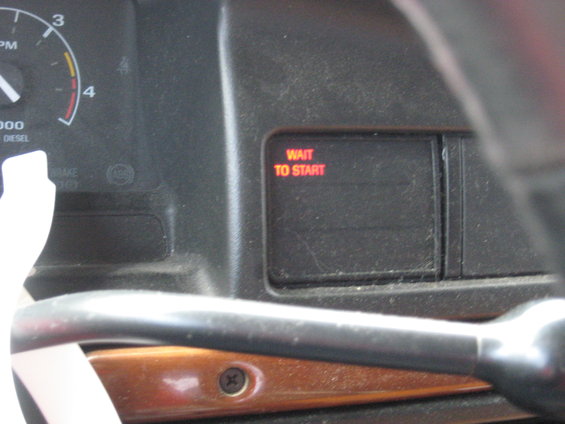 Dashboard interior with tachometer and red "WAIT TO START" indicator light