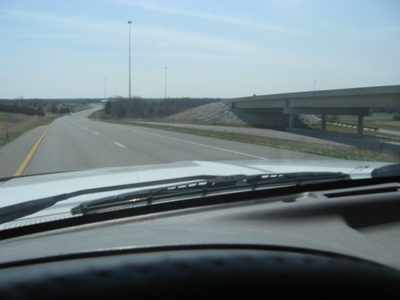 Interior view of a car driving on a highway with a bridge ahead