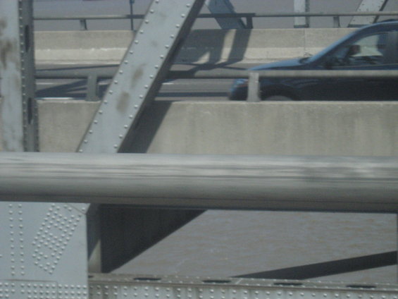 Black SUV driving on a bridge, side view