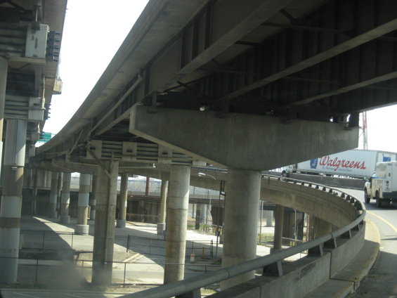 White Walgreens truck and other vehicles on a highway overpass with concrete supports