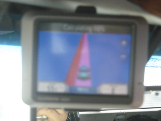 GPS navigation screen showing a route with a pink cone and a car icon
