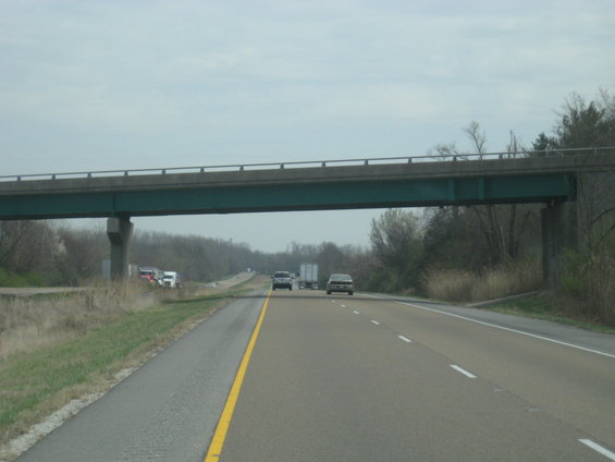 Highway scene with cars and trucks under a bridge