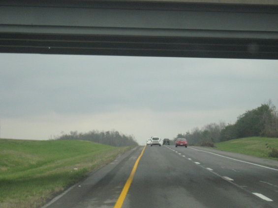 Driving on a highway under an overpass with a few cars ahead