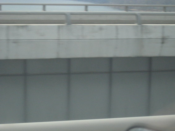 view of a concrete overpass from a moving vehicle
