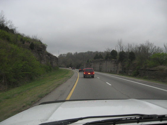 Red SUV driving on highway, seen from behind