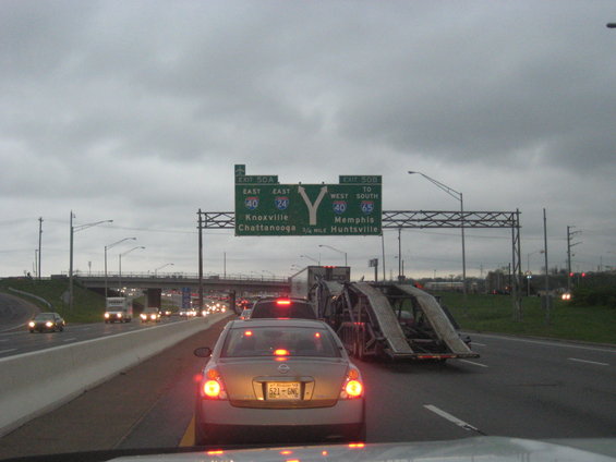 Highway traffic under a cloudy sky with signs for exits 50A and 50B