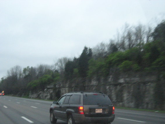 Dark SUV from rear on highway, license plate visible