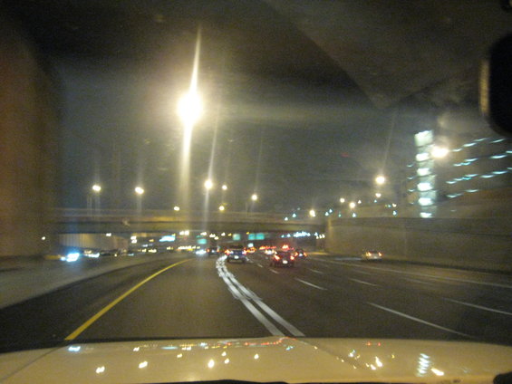 Highway at night with streetlights and other vehicles visible