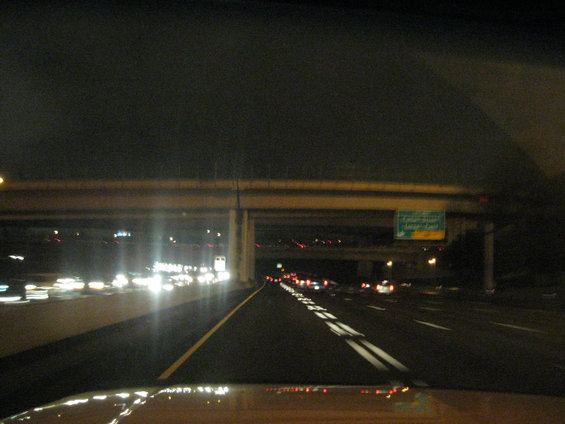 Highway at night with traffic and an overpass