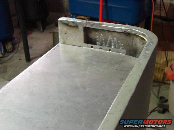 Aluminum panel with welded edges and drilled holes, showing signs of fabrication