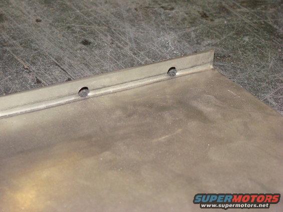 Metal panel with two drilled holes and a folded edge