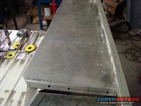 metal sheet being worked on with tape measure and welding torch nearby