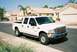 2002 Ford F-250 - A white 2002 Ford F-250 Super Duty pickup truck is parked on a suburban street.