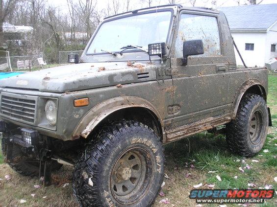 Muddy 1987 Suzuki Samurai parked in a yard