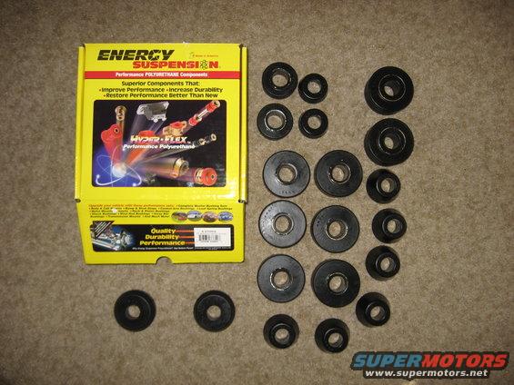 Yellow Energy Suspension box and assorted black polyurethane bushings on a carpeted surface