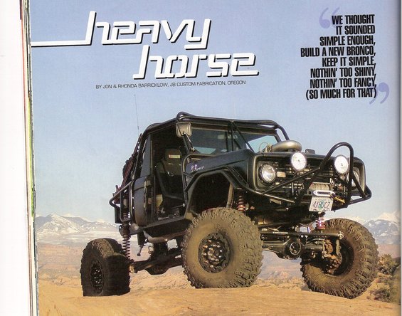 Black modified Ford Bronco with large tires and roll cage, front 3/4 view