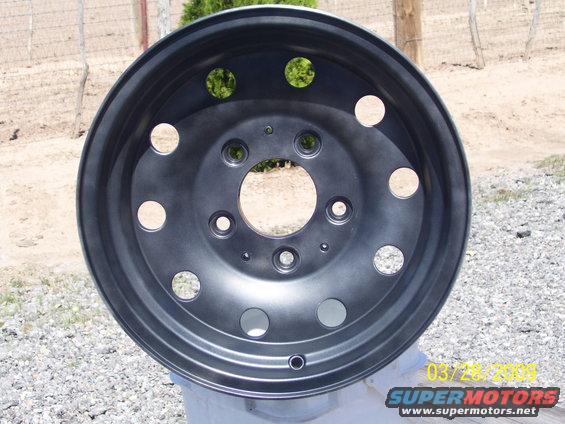 dark gray metal wheel with multiple circular cutouts